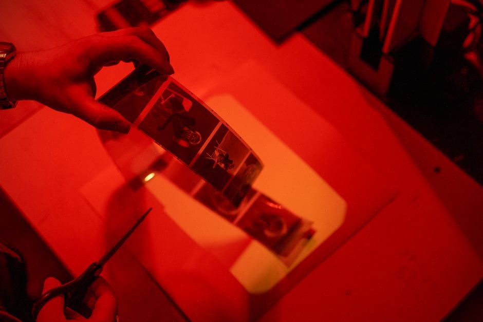 Technicien manipulant un film près d’un copieur ancien