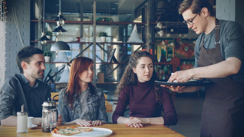Restaurateur lisant un mauvais avis Google derrière son comptoir